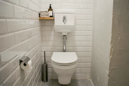 WC avec lave-main intégré dans une petite salle de bain parisienne avec carrelage blanc et robinetterie chromée